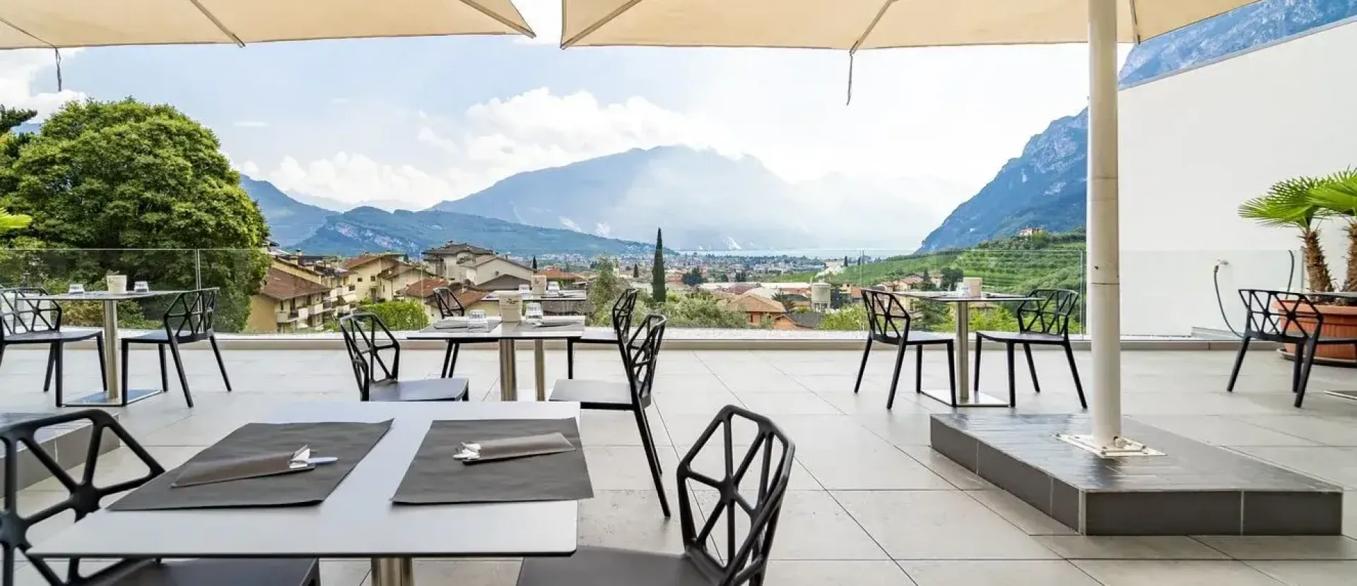 Terrazza con tavoli e sedie, vista montagna, atmosfera rilassante e panoramica incantevole.