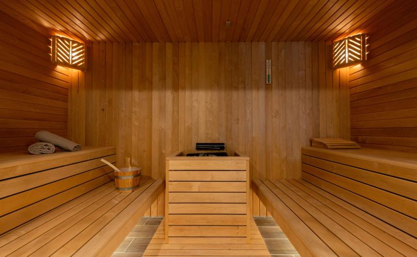 Warm, inviting wooden sauna with soft lighting and benches.
