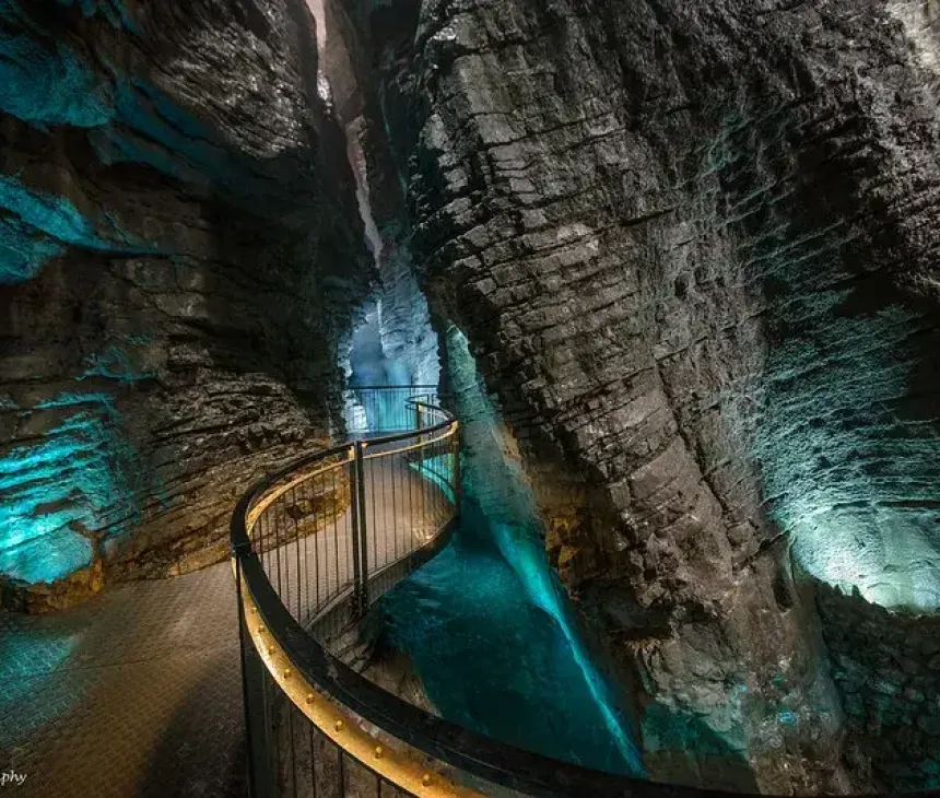 Passerella curva in una grotta con luce blu, atmosfera magica e surreale.