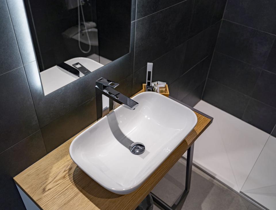 Lavabo moderno su legno, eleganza minimalista in un bagno dai toni scuri.