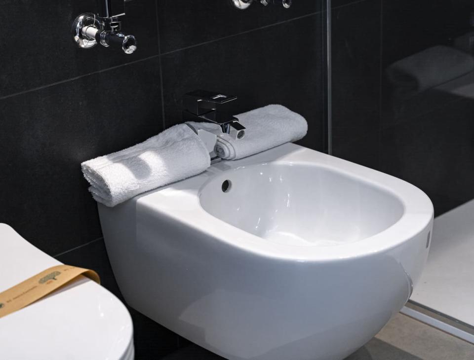Bagno elegante, bidet bianco con asciugamano morbido, atmosfera moderna e rilassante.